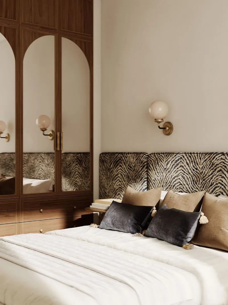 Chambre aux portes en arche, tête de lit zébrée et coussins en velours